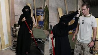 戦利品のツアー-床を掃除するイスラム教徒の女性が角質のアメリカ兵に気づかれる
